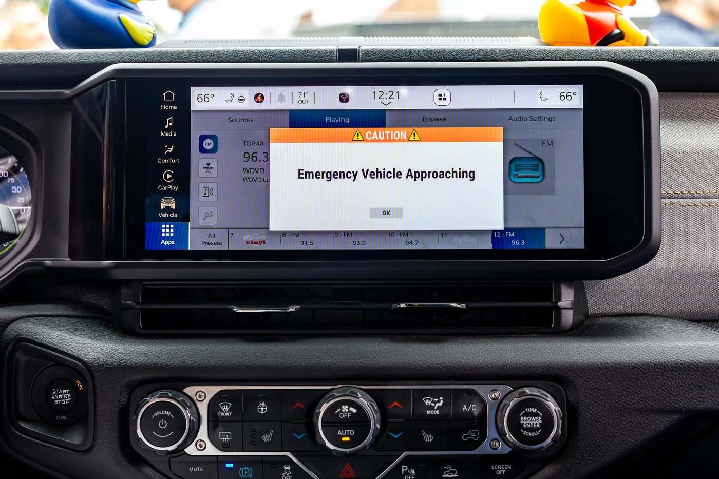 L'écran d'infodivertissement d'une voiture affichant une alerte de véhicule d'urgence reçue par le réseau